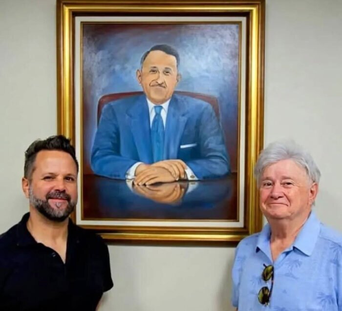 Chris Smahlik with his father, Peter Smahlik, in front of a portrait of founder Ettore Steccone, reflecting the family leadership that has carried the company forward through generations, including Diane Steccone Smahlik, who helped shape its direction. 